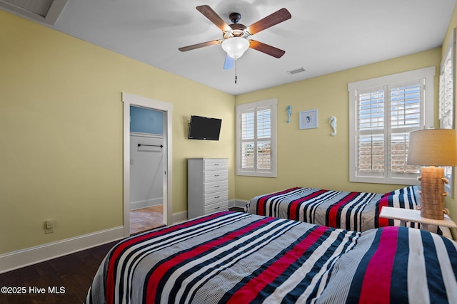 bedroom with baseboards, multiple windows, visible vents, and wood finished floors