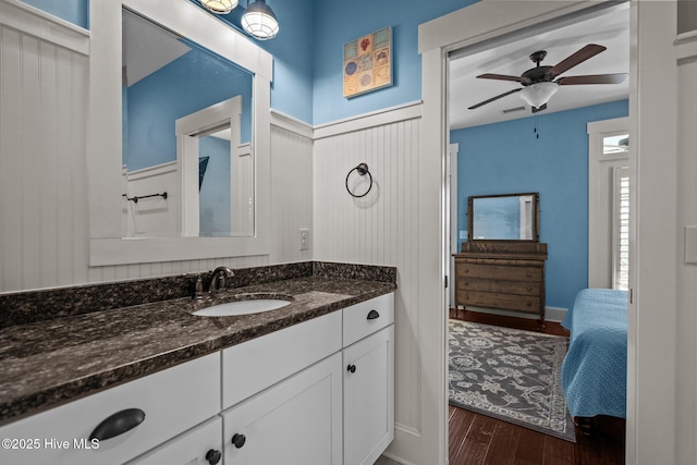 6430 Craller Way, Ocean Isle Beach, NC 28469 - bathroom featuring wood finished floors, vanity, a ceiling fan, and wainscoting