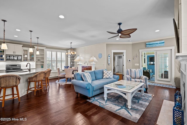 living room featuring ornamental molding, dark wood-style flooring, a high end fireplace, and recessed lighting