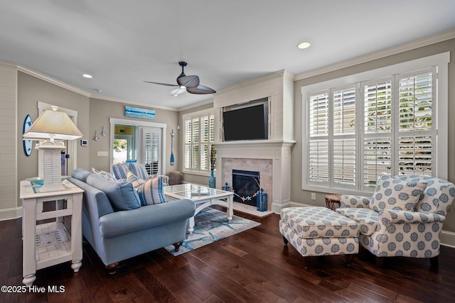 living room featuring crown molding, ceiling fan, wood finished floors, and a fireplace with flush hearth