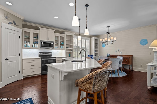 kitchen with ornamental molding, stainless steel appliances, a sink, and light countertops