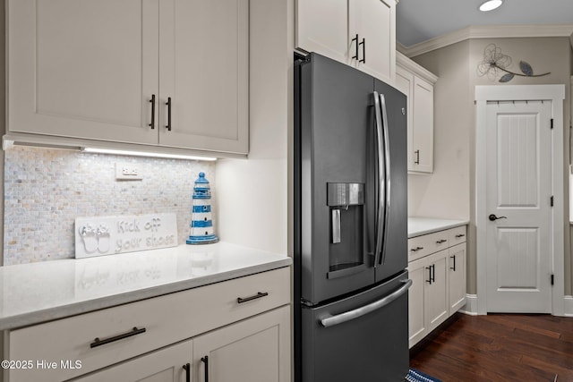 kitchen with light countertops, stainless steel fridge, white cabinetry, and crown molding