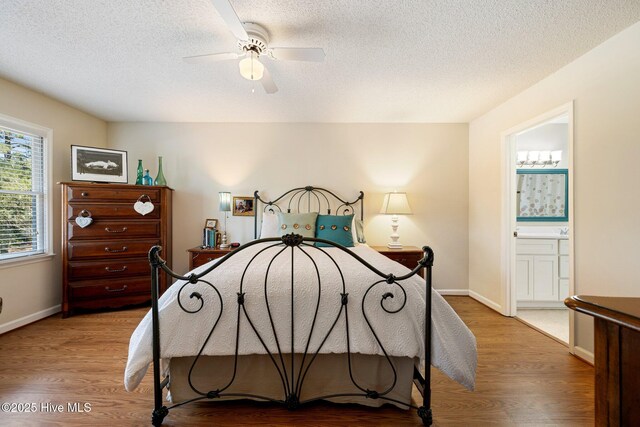 bedroom featuring a textured ceiling, light wood-style flooring, and baseboards
