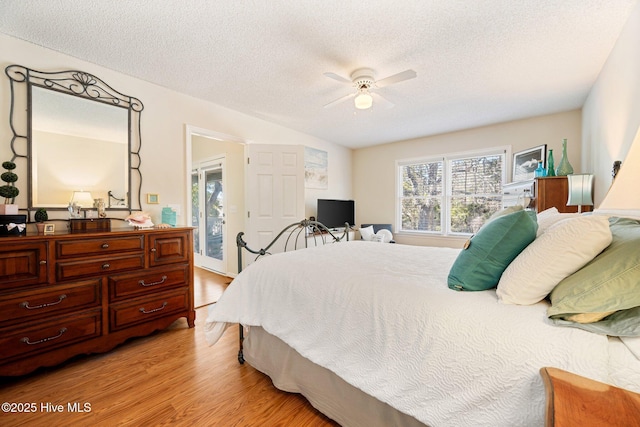 bedroom with light wood finished floors, ceiling fan, and a textured ceiling