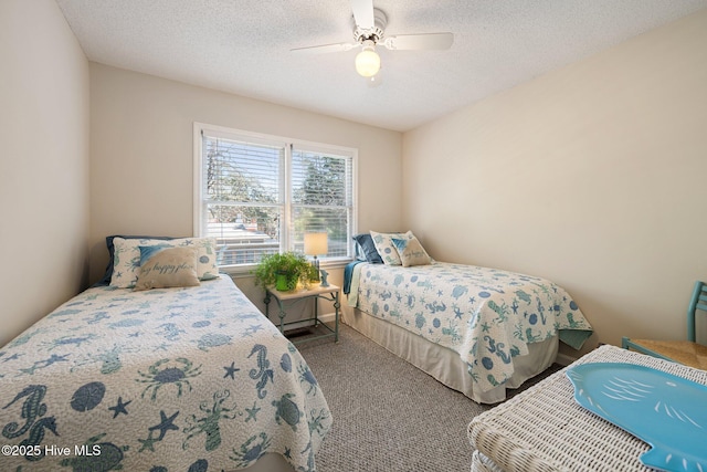 carpeted bedroom with ceiling fan and a textured ceiling