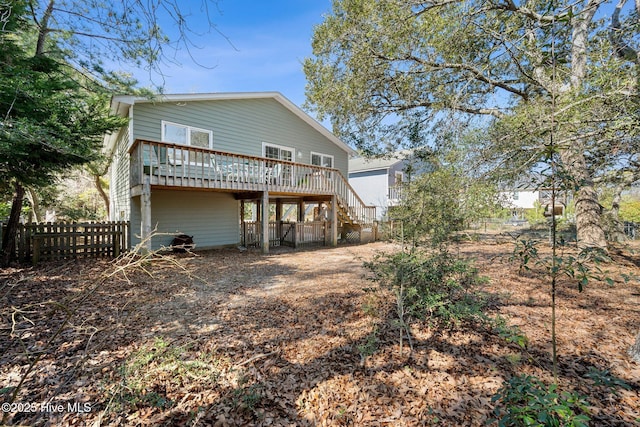 back of property featuring a deck, fence, stairs, dirt driveway, and a carport