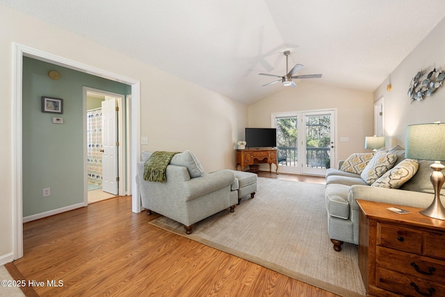 living room with light wood finished floors, ceiling fan, baseboards, and vaulted ceiling