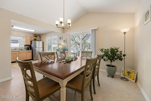 dining room featuring a notable chandelier, vaulted ceiling, and baseboards
