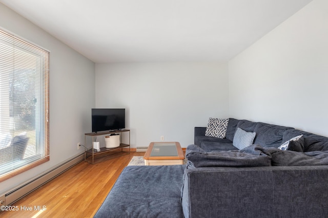 living area with light wood-style flooring, baseboards, and baseboard heating