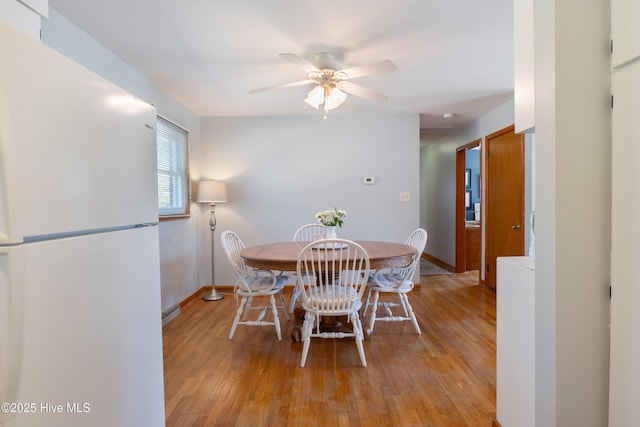 dining room featuring light wood-type flooring, ceiling fan, and baseboards