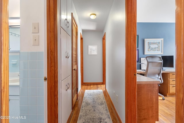 hallway featuring light wood-style floors and baseboards