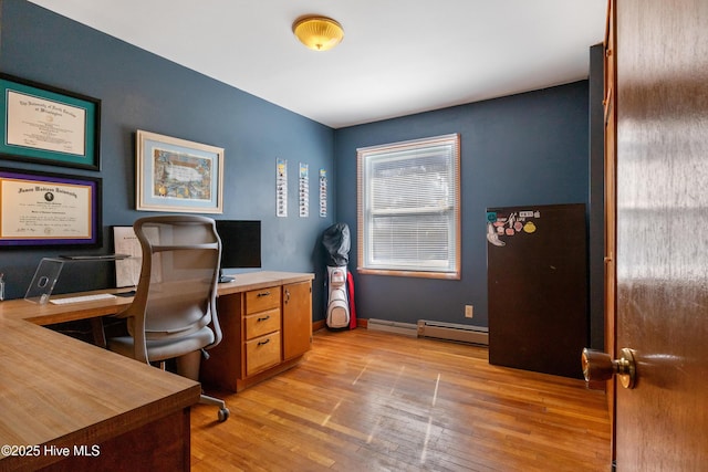 office space featuring a baseboard heating unit, light wood-type flooring, and baseboards