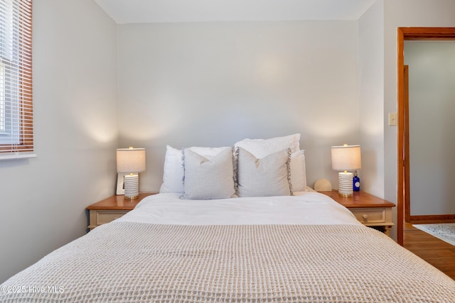 bedroom featuring baseboards and wood finished floors