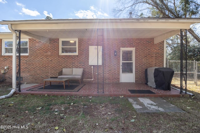 back of house featuring brick siding, fence, and a patio