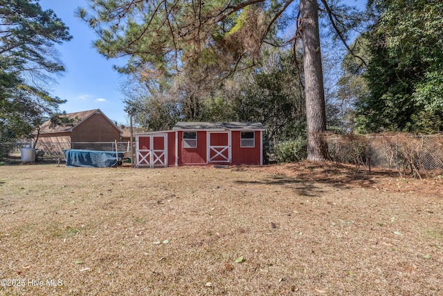 view of yard featuring a storage shed, fence, and an outdoor structure