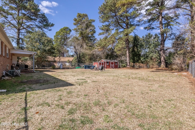 view of yard with an outbuilding, a fenced backyard, and a storage unit