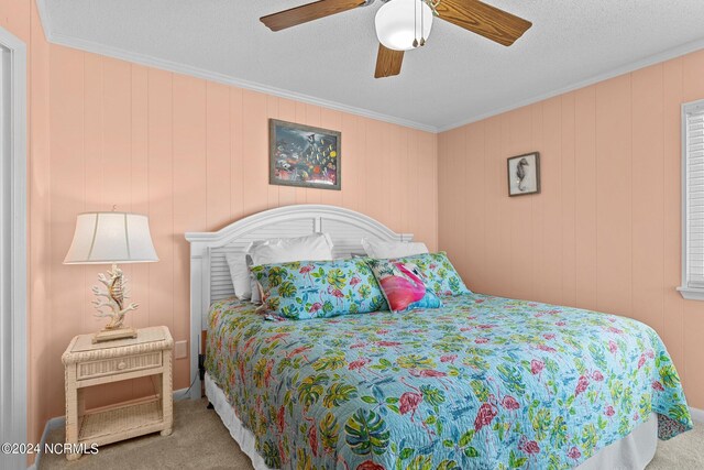 bedroom with carpet flooring, crown molding, a textured ceiling, and ceiling fan