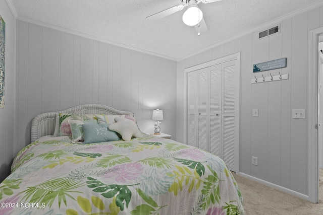 carpeted bedroom with ornamental molding, a closet, visible vents, and a textured ceiling