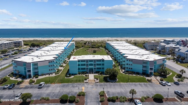 birds eye view of property with a water view and a beach view