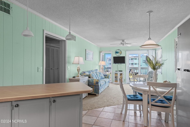 dining area with light carpet, a textured ceiling, visible vents, and crown molding