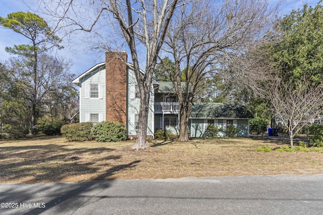 view of home's exterior featuring a chimney and a balcony