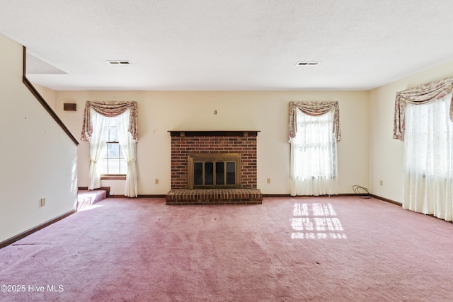 unfurnished living room with plenty of natural light, carpet flooring, a fireplace, and baseboards