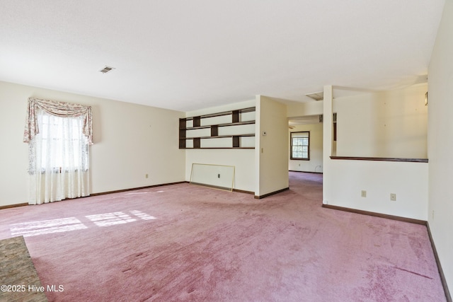 spare room with carpet, visible vents, and baseboards