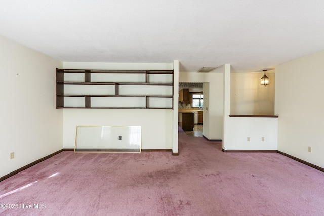 unfurnished living room with carpet floors and baseboards