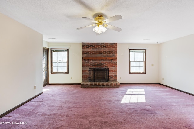 unfurnished living room featuring visible vents, baseboards, a textured ceiling, carpet floors, and a brick fireplace