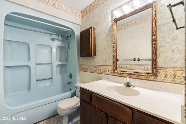 bathroom featuring shower / bathing tub combination, vanity, toilet, and wallpapered walls