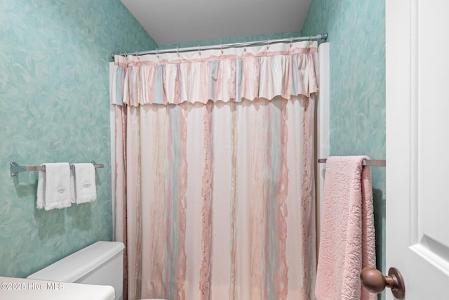 full bathroom featuring a shower with shower curtain, toilet, and wallpapered walls