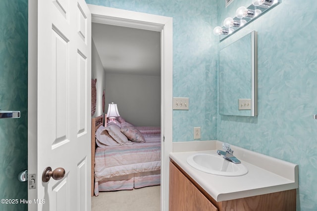 bathroom with vanity, ensuite bathroom, and wallpapered walls