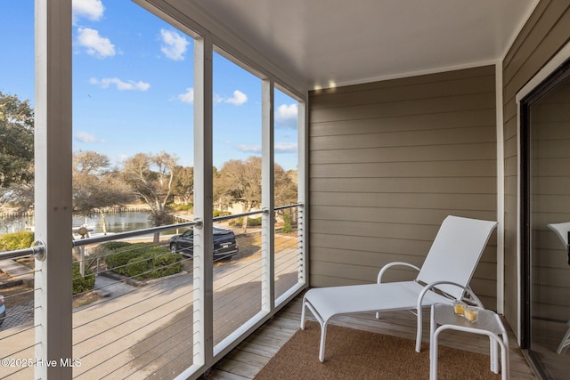 sunroom / solarium featuring a water view