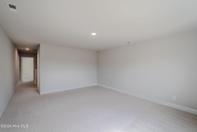 unfurnished room with recessed lighting, visible vents, light carpet, and baseboards