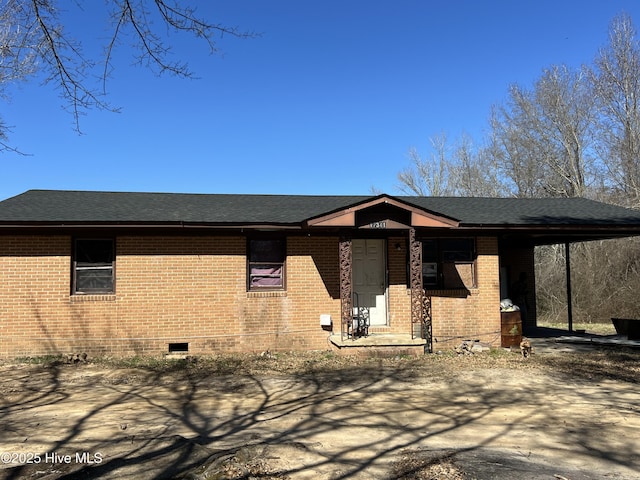 view of front facade featuring roof with shingles, brick siding, and crawl space