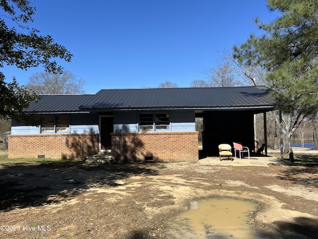 exterior space featuring metal roof, brick siding, and crawl space