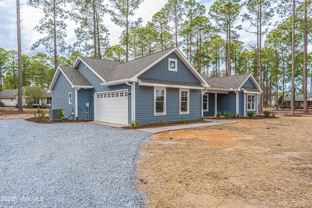 view of front of home featuring a garage, central AC, driveway, and roof with shingles