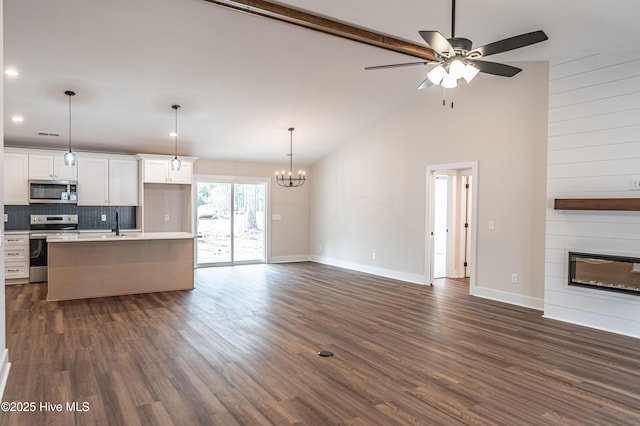 kitchen featuring dark wood finished floors, appliances with stainless steel finishes, open floor plan, and light countertops