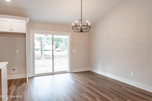 unfurnished dining area with dark wood-style floors, a chandelier, and baseboards