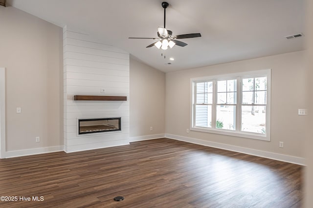 unfurnished living room featuring a large fireplace, baseboards, visible vents, lofted ceiling, and dark wood-style flooring