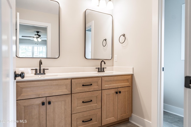 bathroom featuring double vanity, ceiling fan, baseboards, and a sink