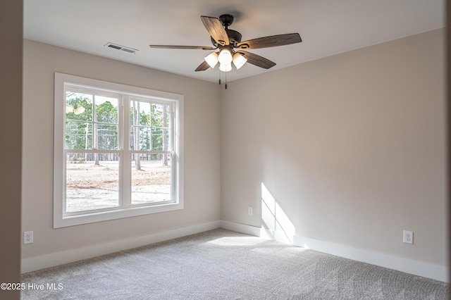 carpeted spare room with visible vents, ceiling fan, and baseboards