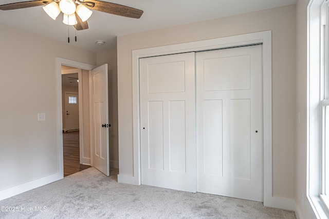 unfurnished bedroom with a closet, carpet flooring, and baseboards