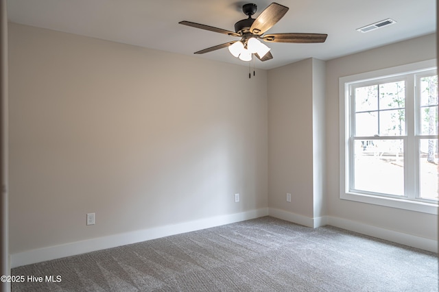 carpeted spare room featuring visible vents, plenty of natural light, and baseboards