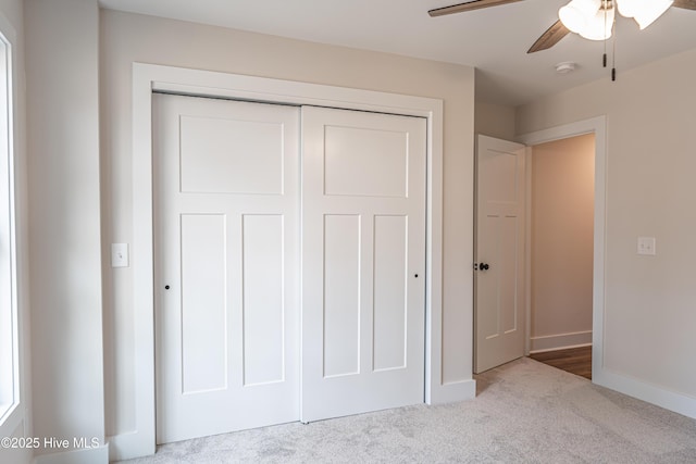 unfurnished bedroom featuring a closet, carpet flooring, a ceiling fan, and baseboards