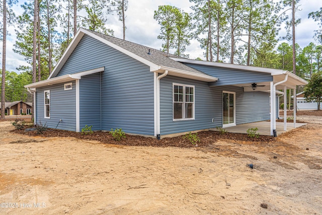 exterior space featuring a patio area, ceiling fan, and roof with shingles