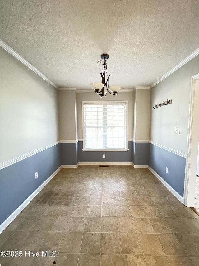 spare room with ornamental molding, visible vents, a notable chandelier, and baseboards