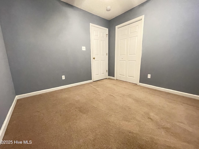 spare room with baseboards and carpet flooring