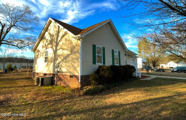 view of side of home featuring crawl space, cooling unit, and a yard