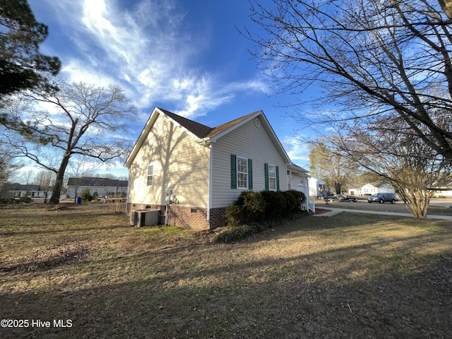 view of property exterior with crawl space, a lawn, and cooling unit